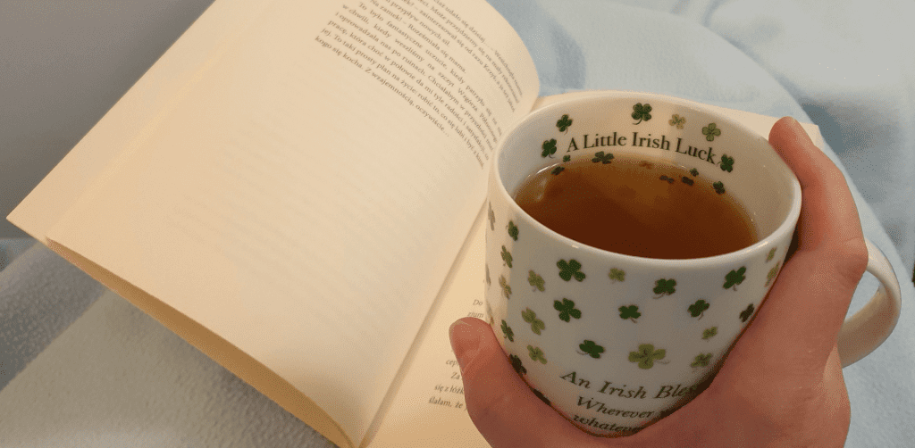 Książka "Przeczucia" z kubkiem w koniczynki z napisem o szczęściu irlandzkim