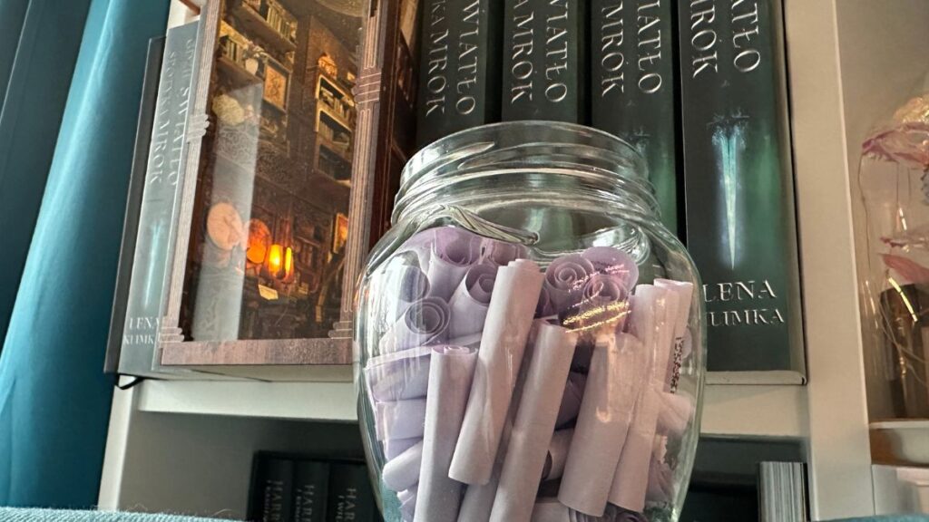 Fioletowe ruloniki z cytatami z książki Leny Klimki wykorzystane jako rytuał słoika