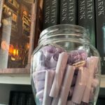 Fioletowe ruloniki z cytatami z książki Leny Klimki wykorzystane jako rytuał słoika